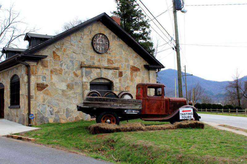 an old whiskey truck outside a stone building