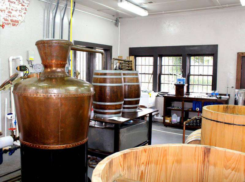 Copper kettles and whiskey barrels at distillery