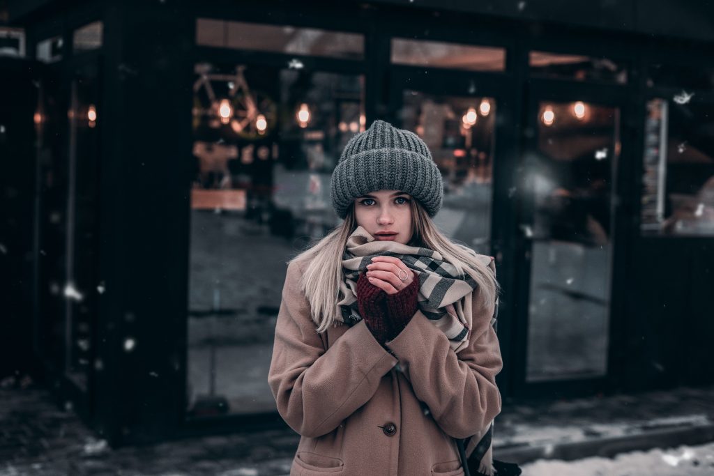 woman in winter clothing sipping hot drink