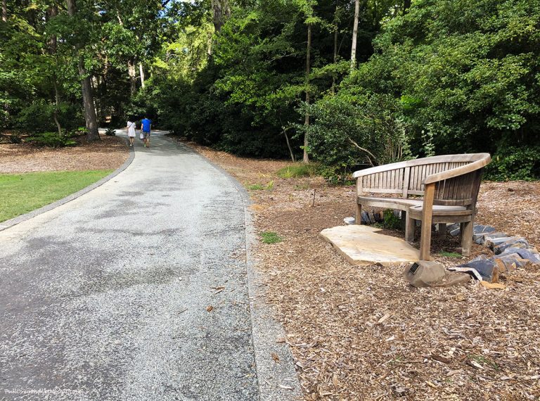 People walking a path by a bench at Sarah P. Duke Gardens. PullOverAndLetMeOut