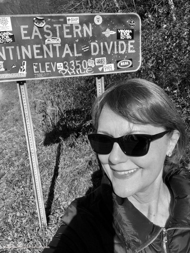 Anna Marie in front of the sign for the Eastern Continental Divide.