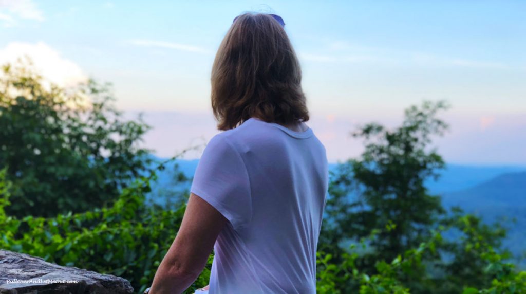 Woman's back to camera as she looks at the mountains.