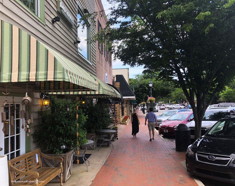 couple strolling down the street hand in hand in Highlands, NC PullOverAndLetMeOut