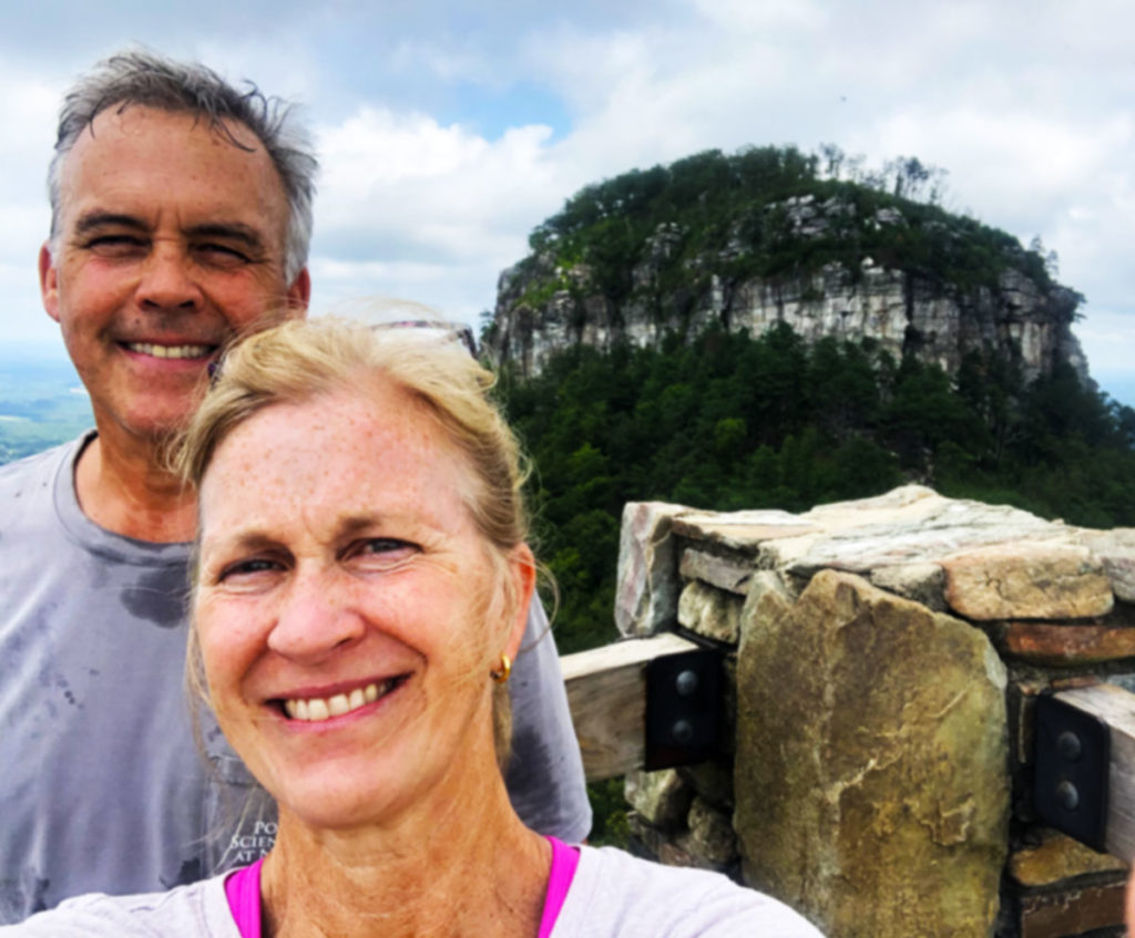 A man and woman taking a selfie in front of Pilot Mountain