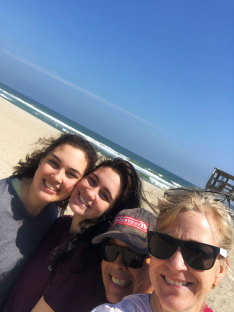 a family posing on the beach