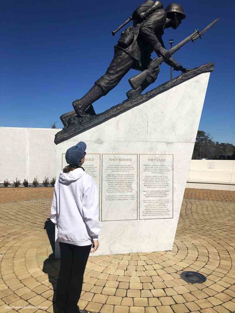 woman looking at a statue at the Montfort Point Marine Memorial