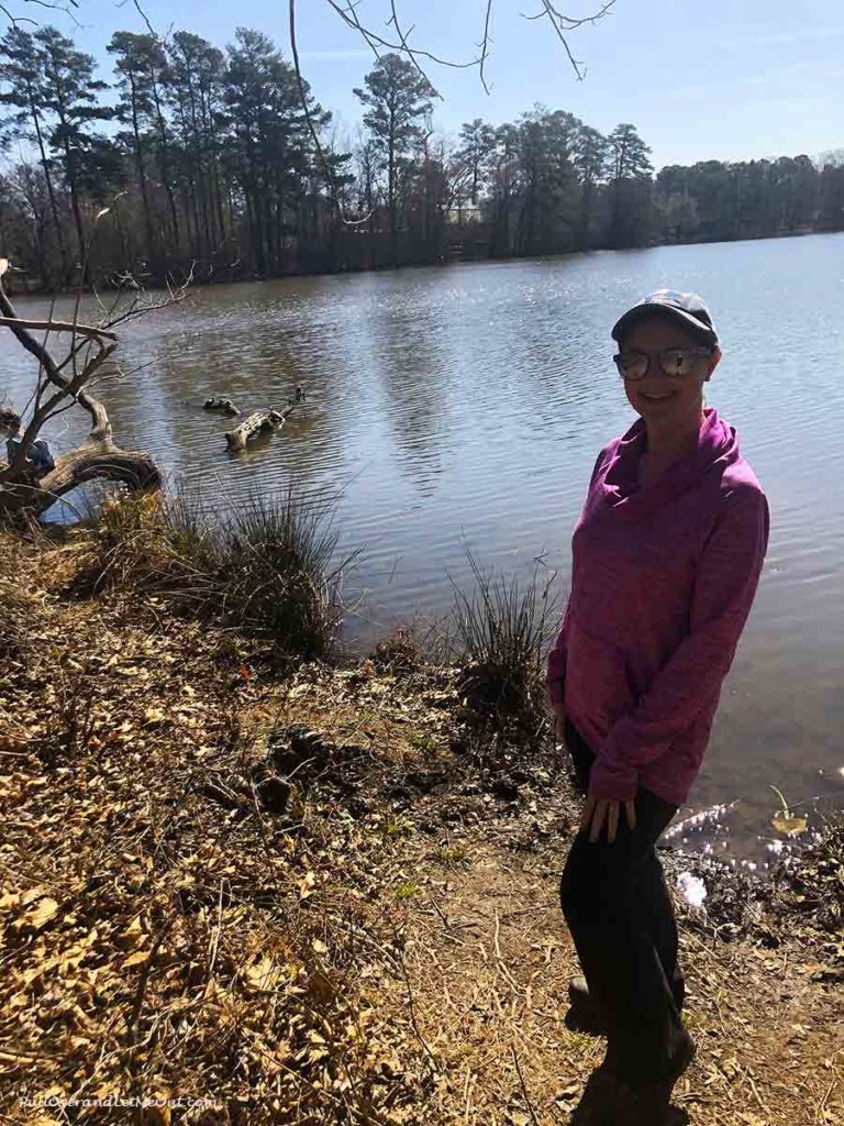 woman standing on the banks of a pond