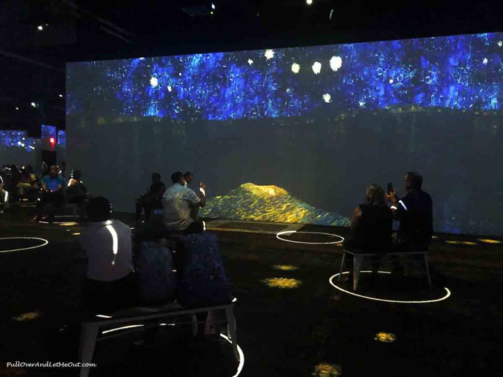 People sitting inside circles at the Immersive Van Gogh Exhibit Charlotte