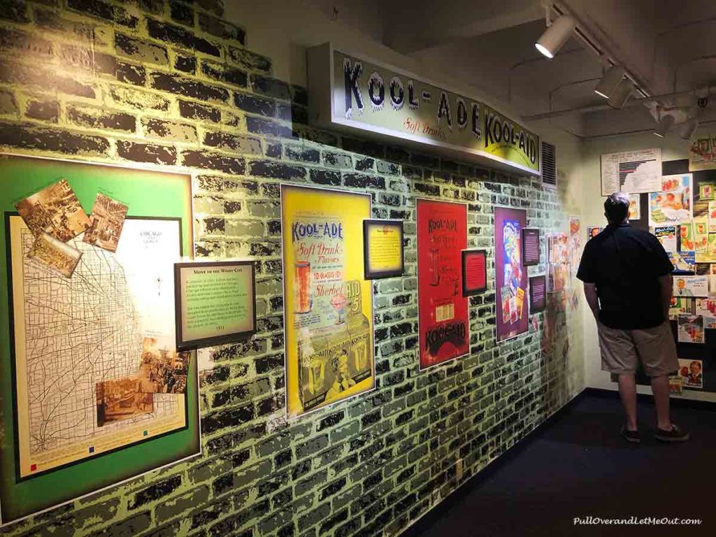 A man looking at a wall exhibit filled with Kool-Aid memorbilia