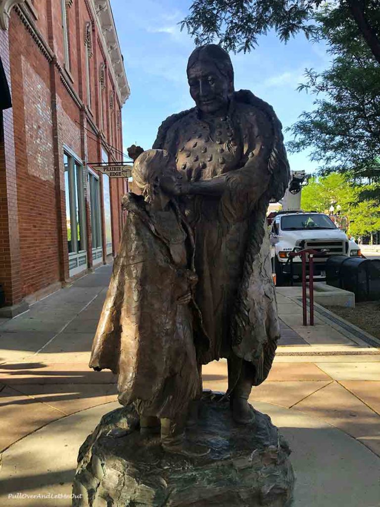 A sculpture of a Native American man and young child