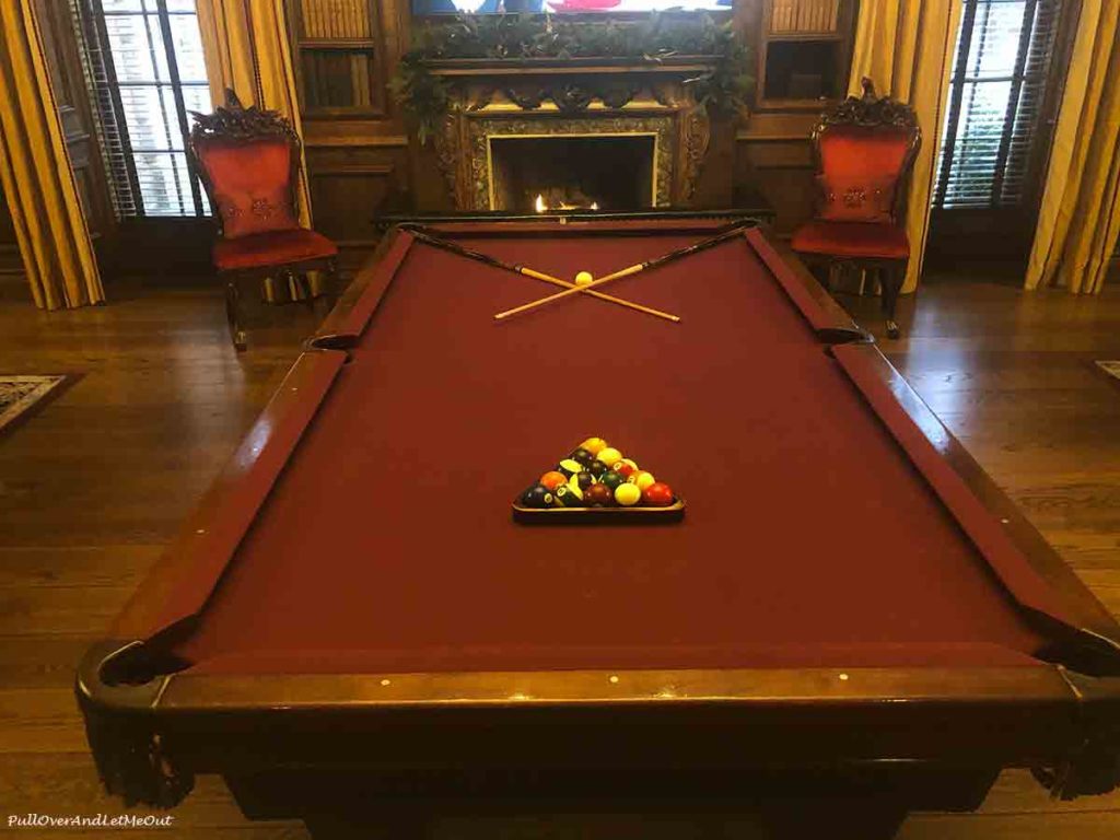 a billiard table with balls racked and sticks crossed