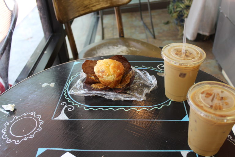 a muffin with two iced coffee drinks
