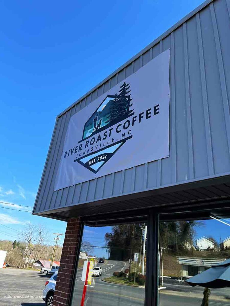 a sign on a building that says River Roast Coffee