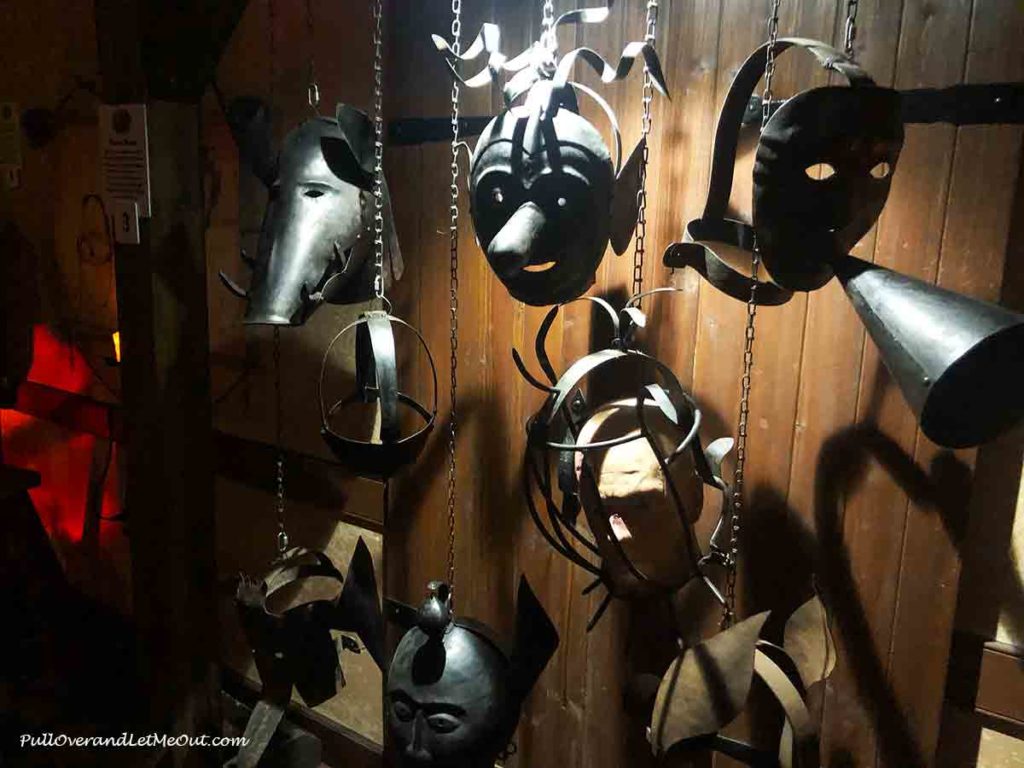 a wall of masks at the Medieval Torture Museum