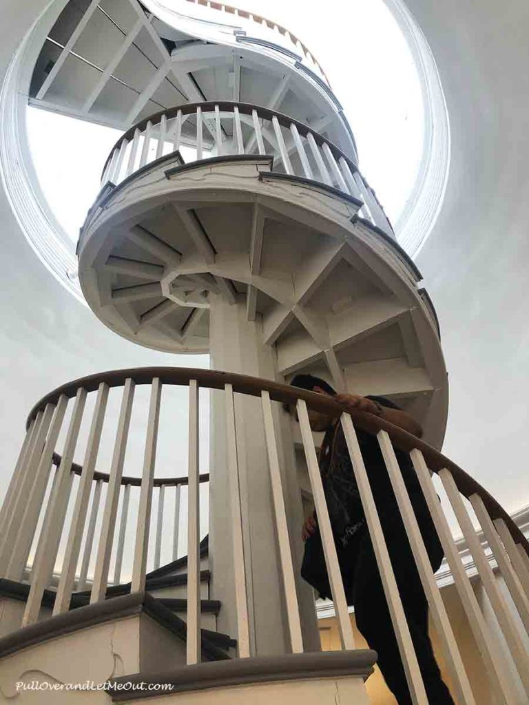 a young man climbing a spiral staircase