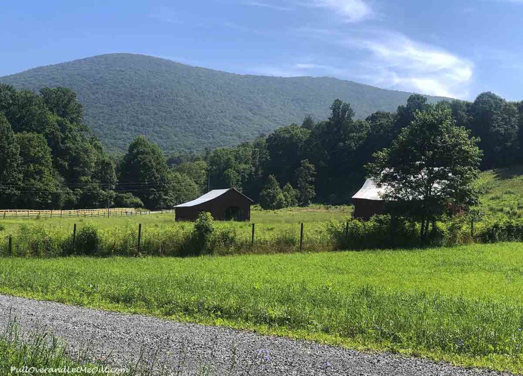 a red barn with a mountain behind it