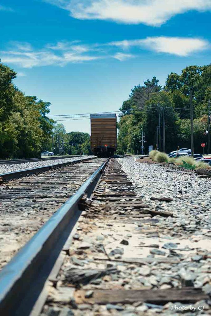 railroad tracks with a train car in the distance