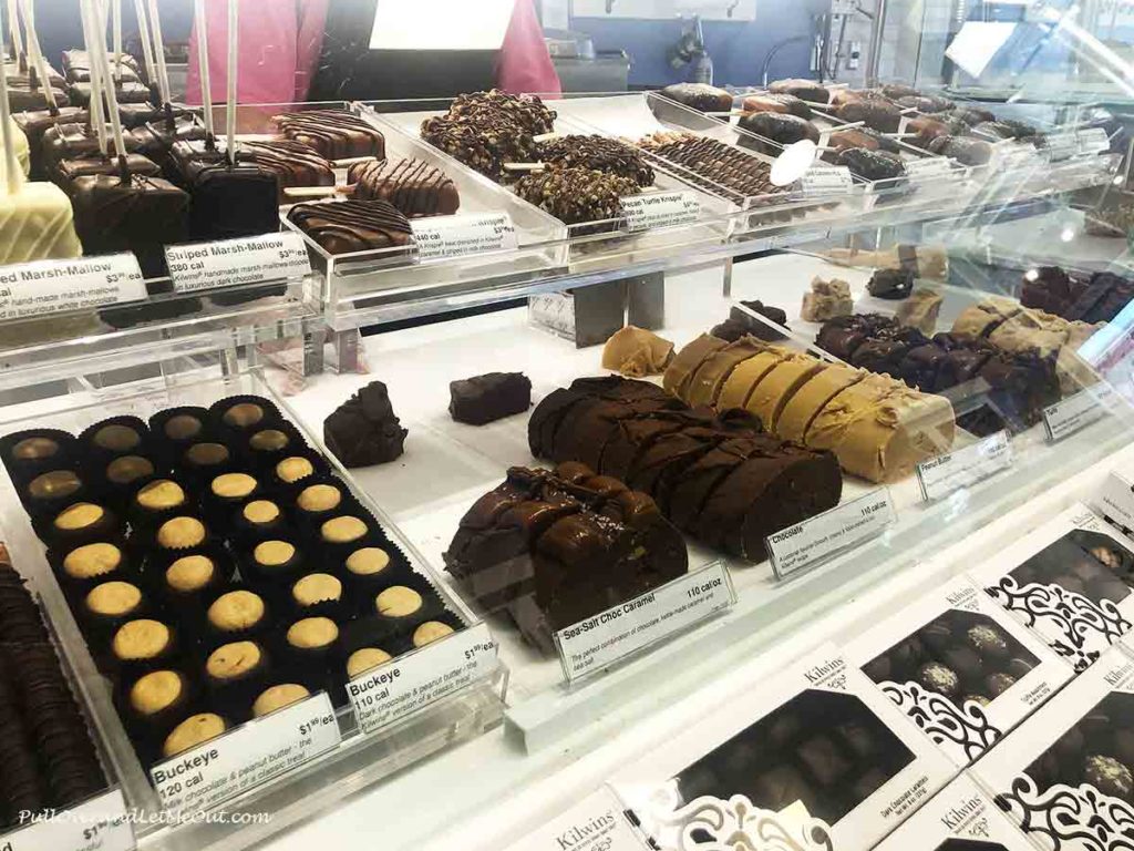 a glass display case with fudge and other candy
