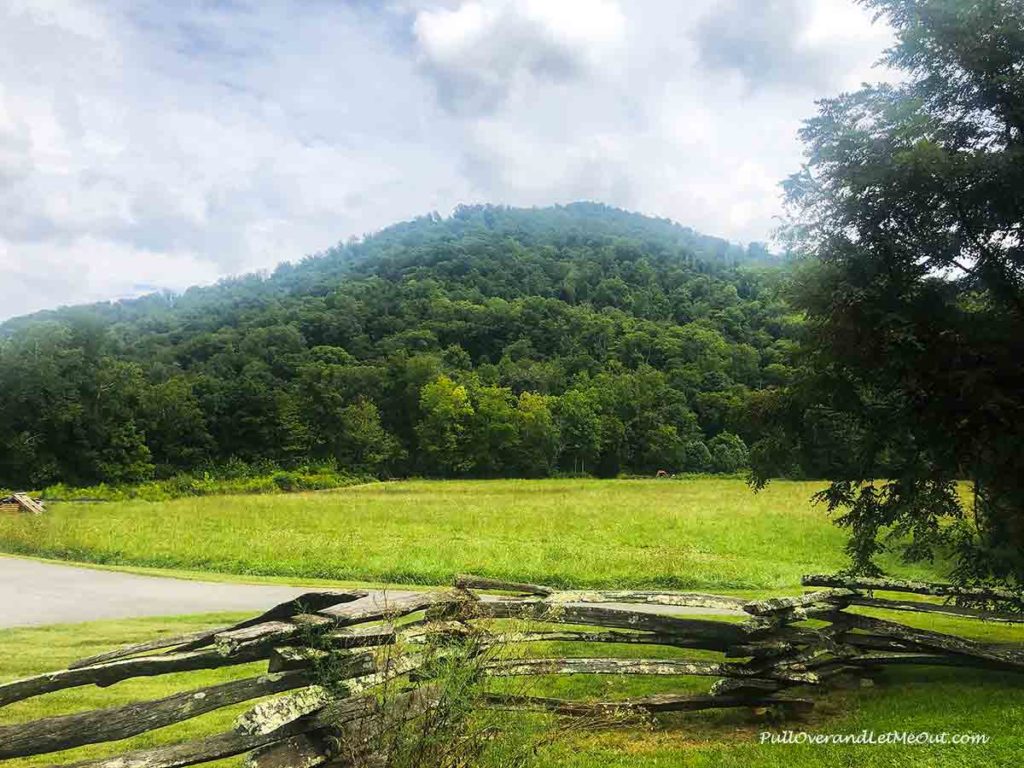 a split rail fence in front of a mountain view