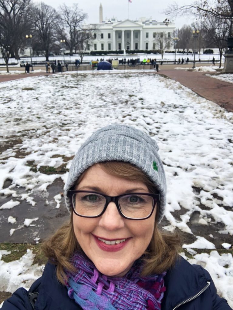 woman in front of the white house in winter