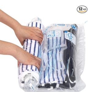 A person rolling a compression bag of clothing.