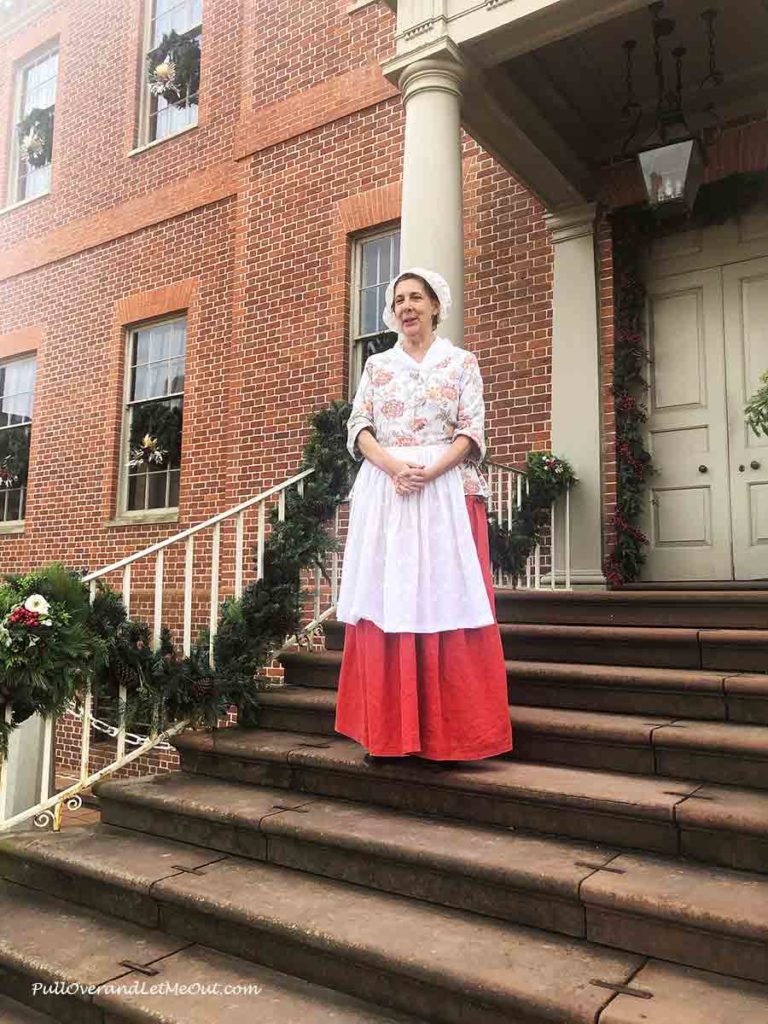 a costumed colonial tour guide at Tryon Palace on the steps out front.