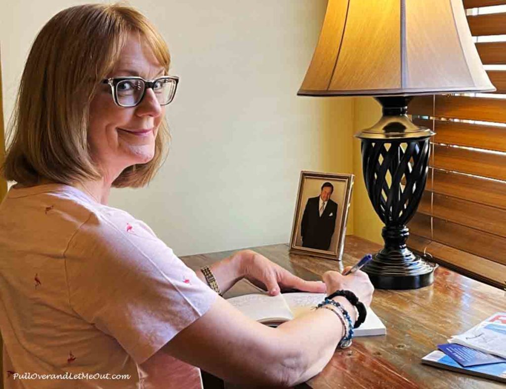 a woman sitting at a desk in front of a picture of Paul Sorvino