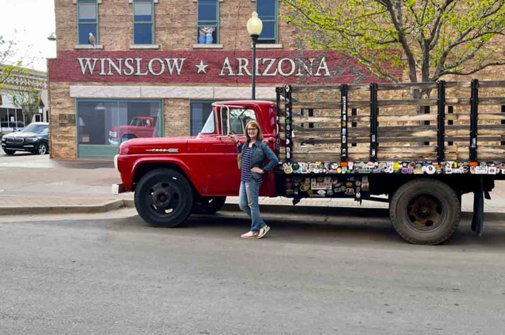 girl in front of a flatbed Ford on a corner in Winslow Arizona