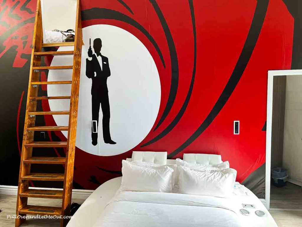 a bed with a painting of a 007 agent behind it