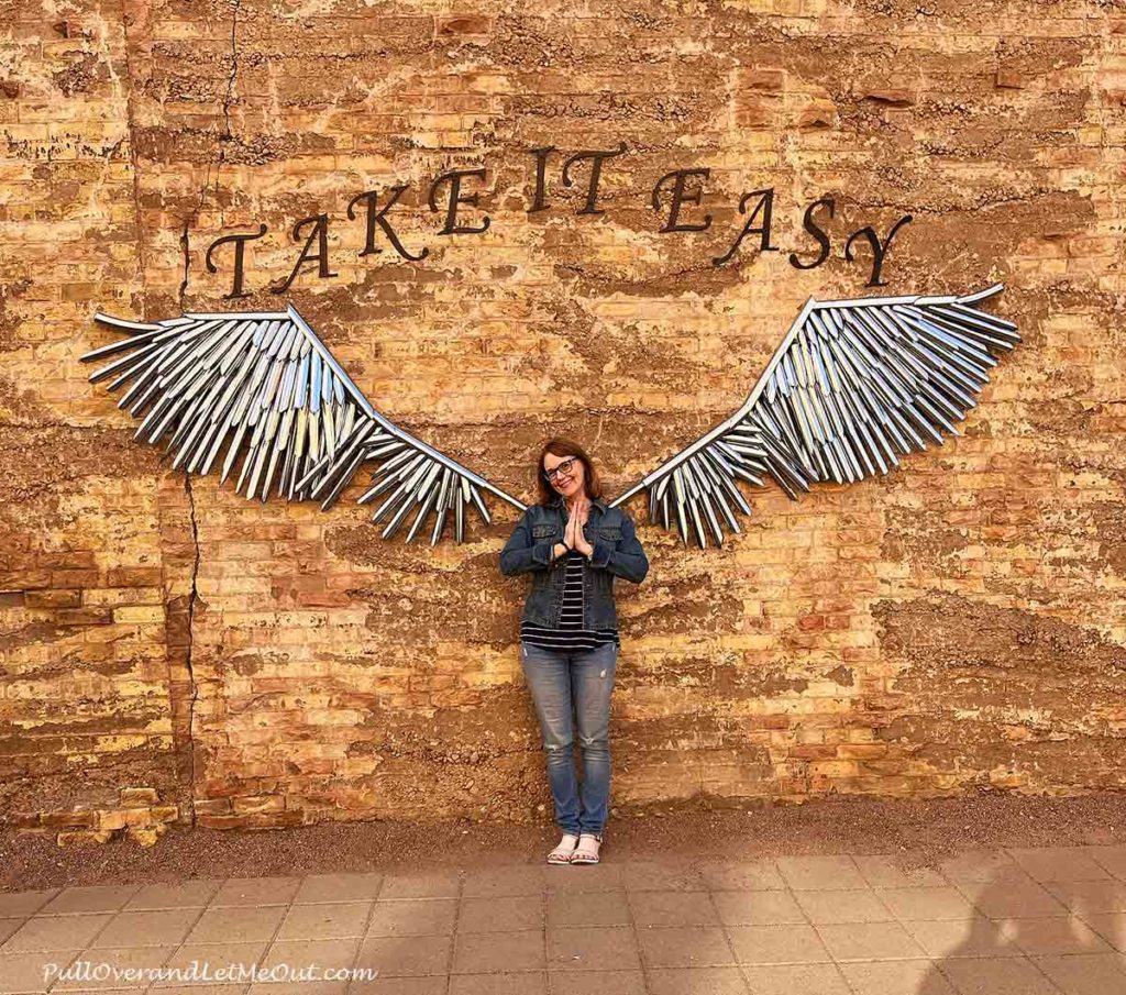 a woman at a wall with wings behind her