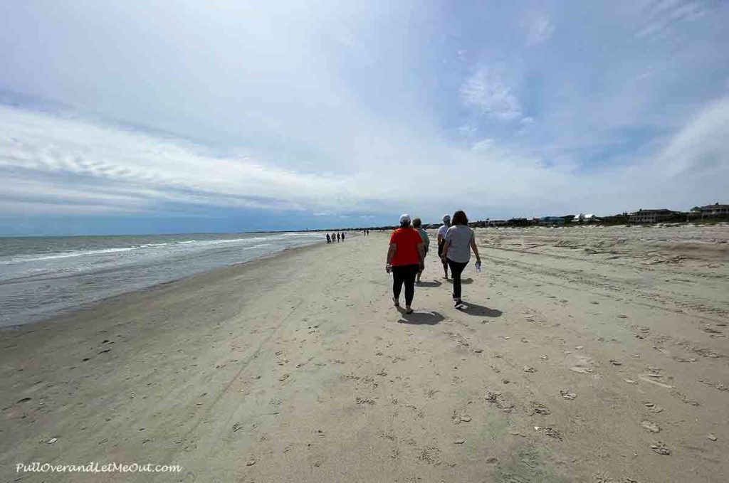 a group of women walking on the beach