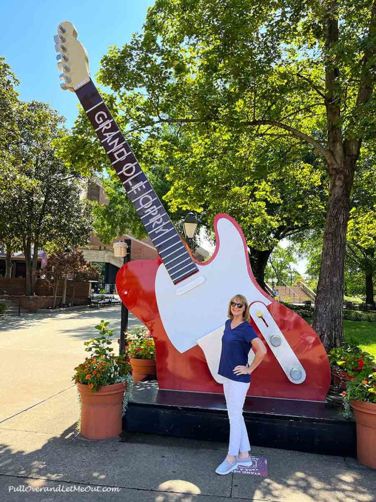 a woman standing in front of a giant electric guitar in Nashville