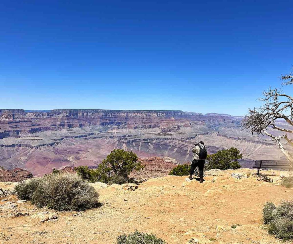 a young man phographing the Grand Canyon