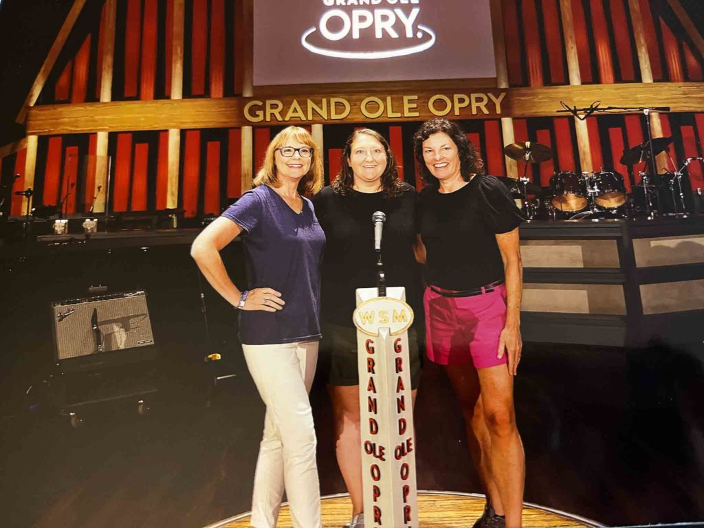 three women on stage at the Grand Ole Opry