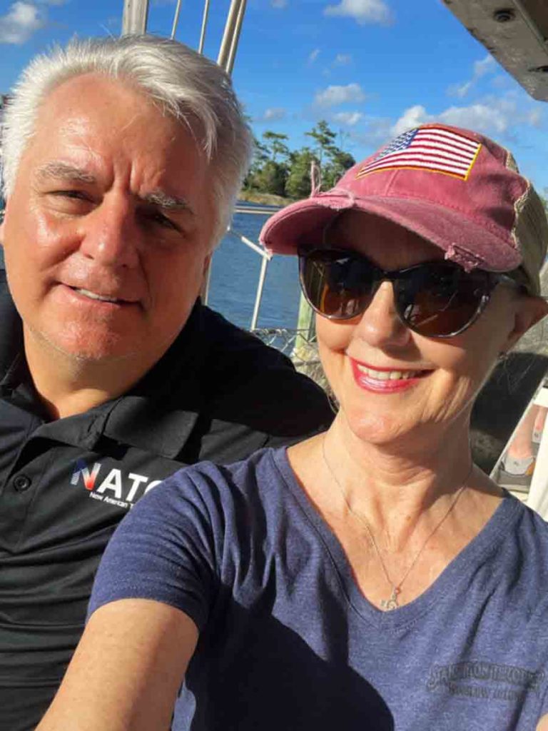 a man and woman taking a selfie on a boat