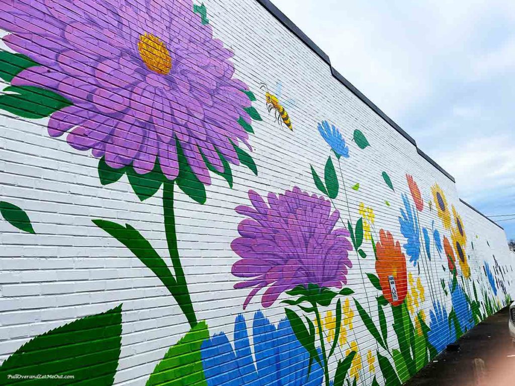 a wall mural with flowers and a bee
