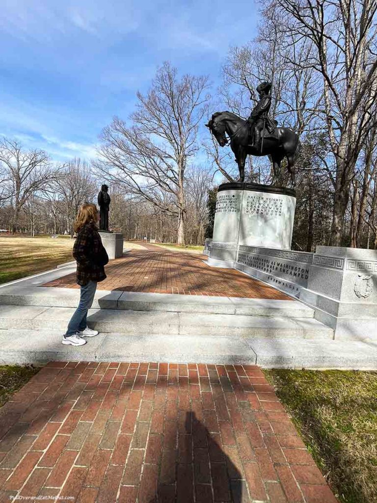 a woman looking at a statue of a soldier on a horse