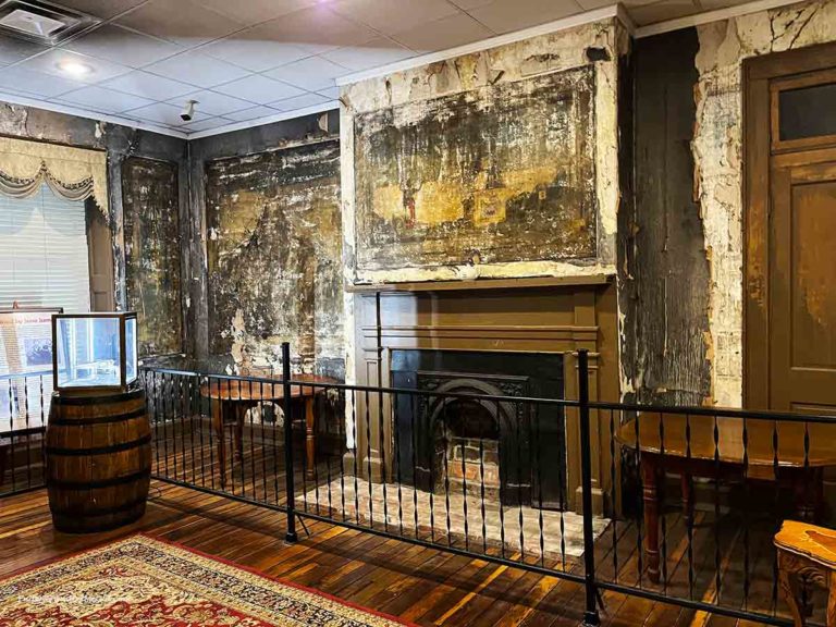 a fireplace with an old mural on the wall around it