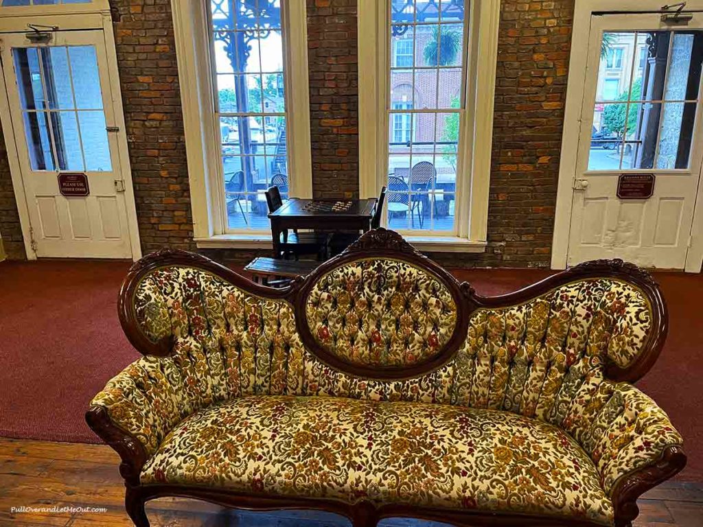 an old-fashioned love seat in front of a window.
