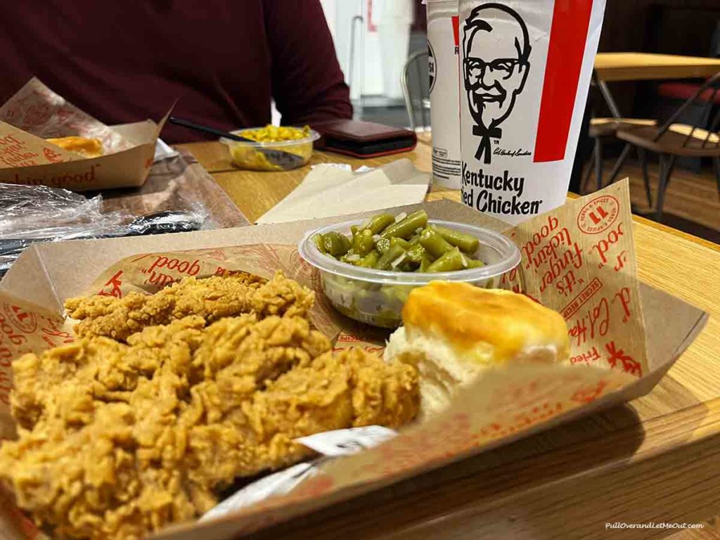 a plate with Kentucky Fried Chicken, a biscuit and green beans