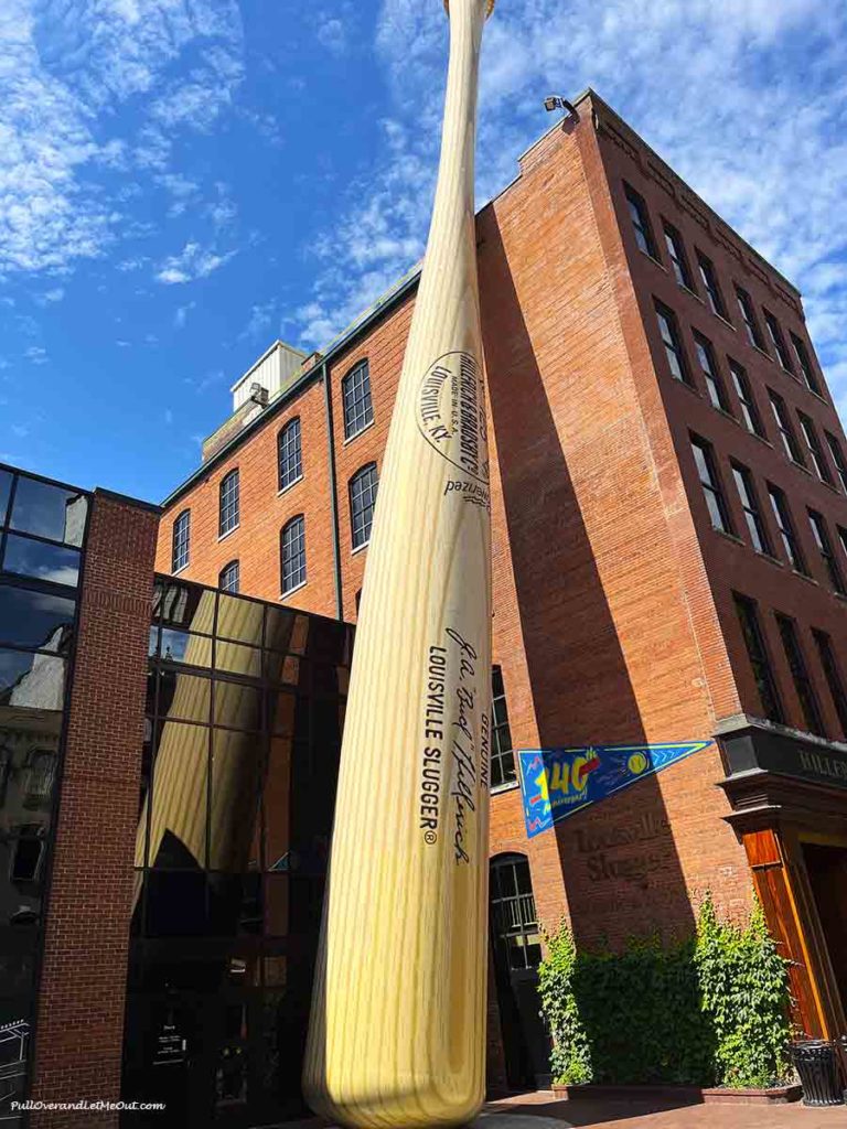 a giant baseball bat in front of a brick building