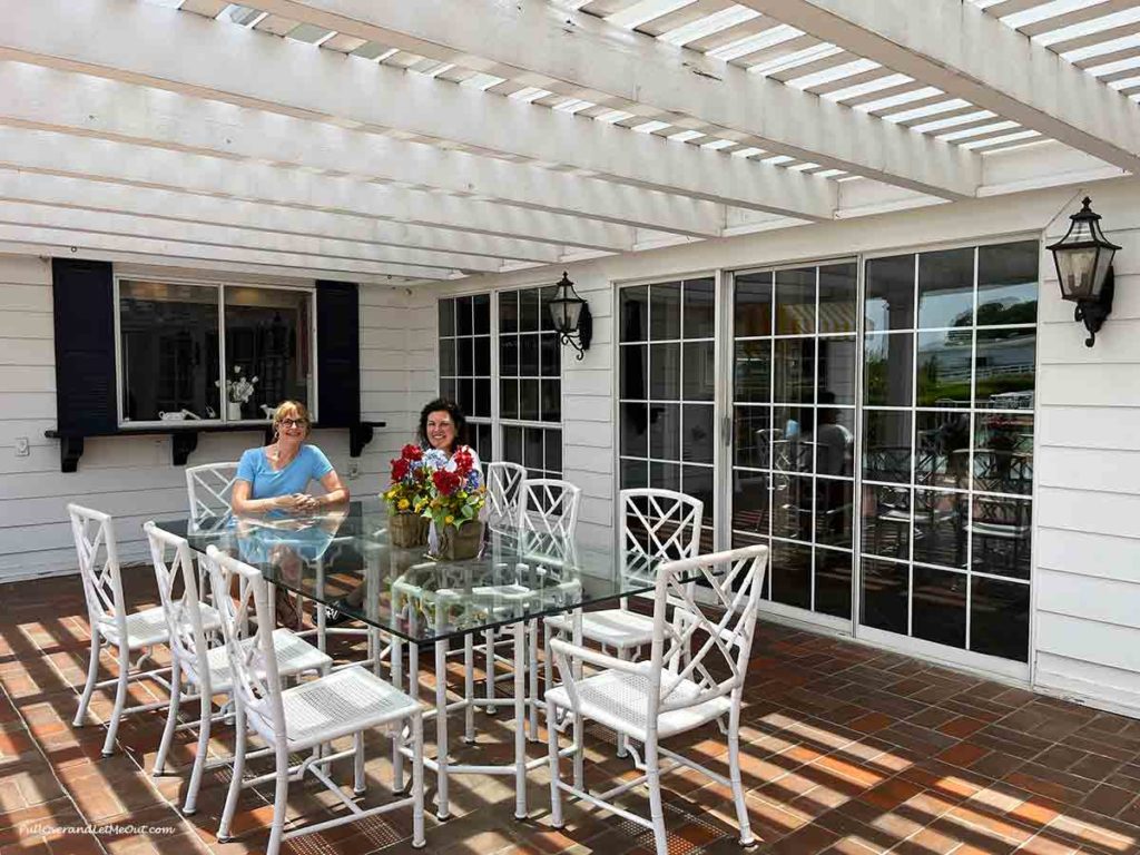 two women seated at a table on a patio