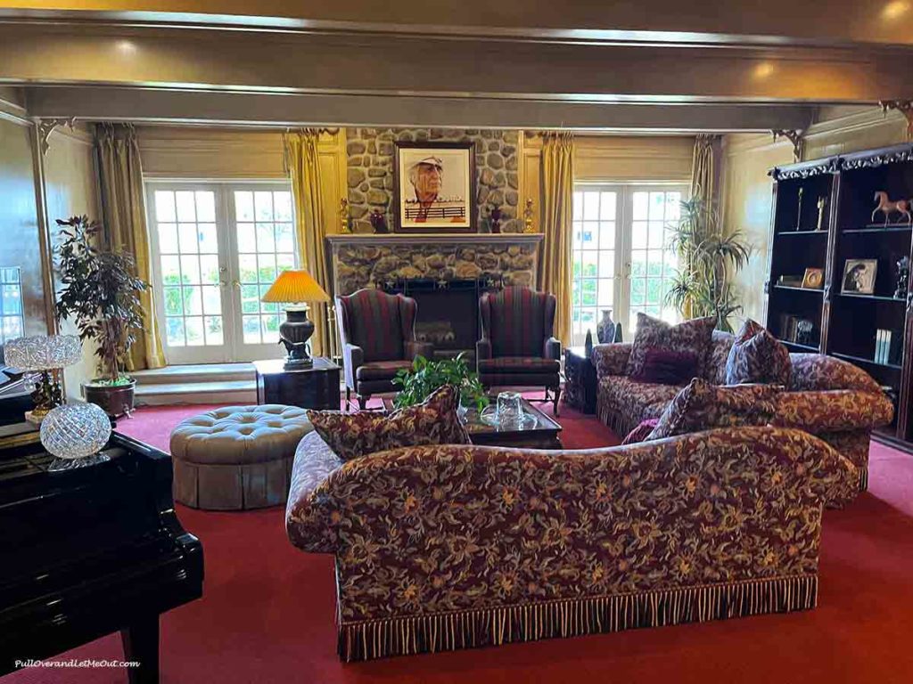 a living room with a man's portrait over the fireplace