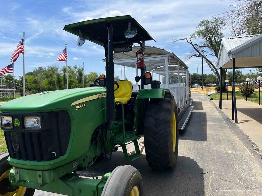 a green tractor pulling a tram