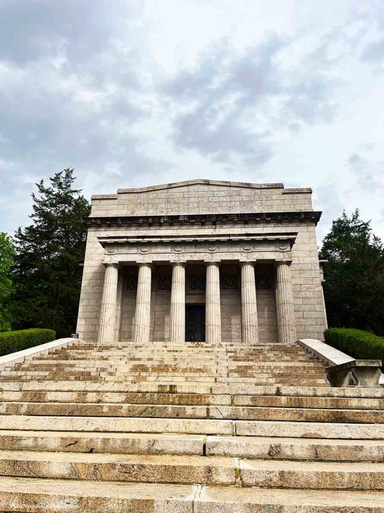 steps leading up to a stone building with large columns at the entrance.