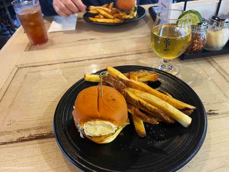 a burger and fries with a beer on the side