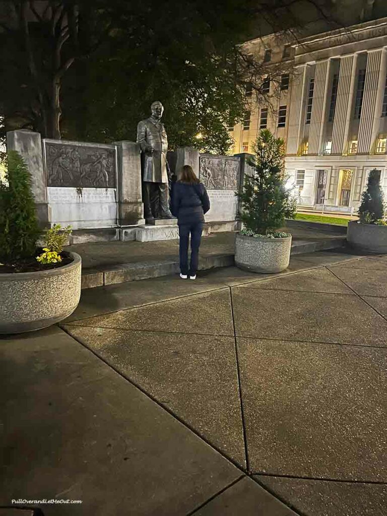 a woman looking at a historic marker