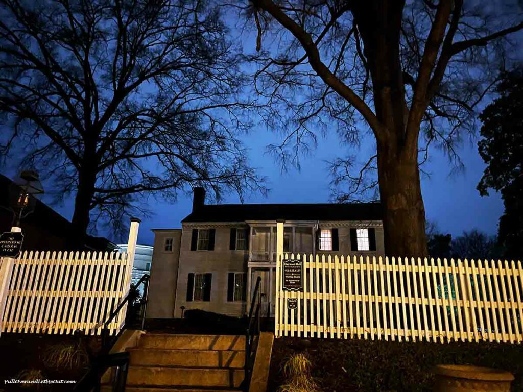 a picket fence in front of a historic home