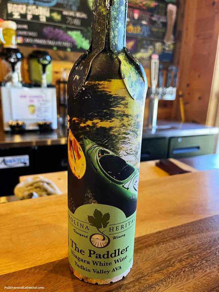 a paper wine bottle placed on top of a wooden bartop