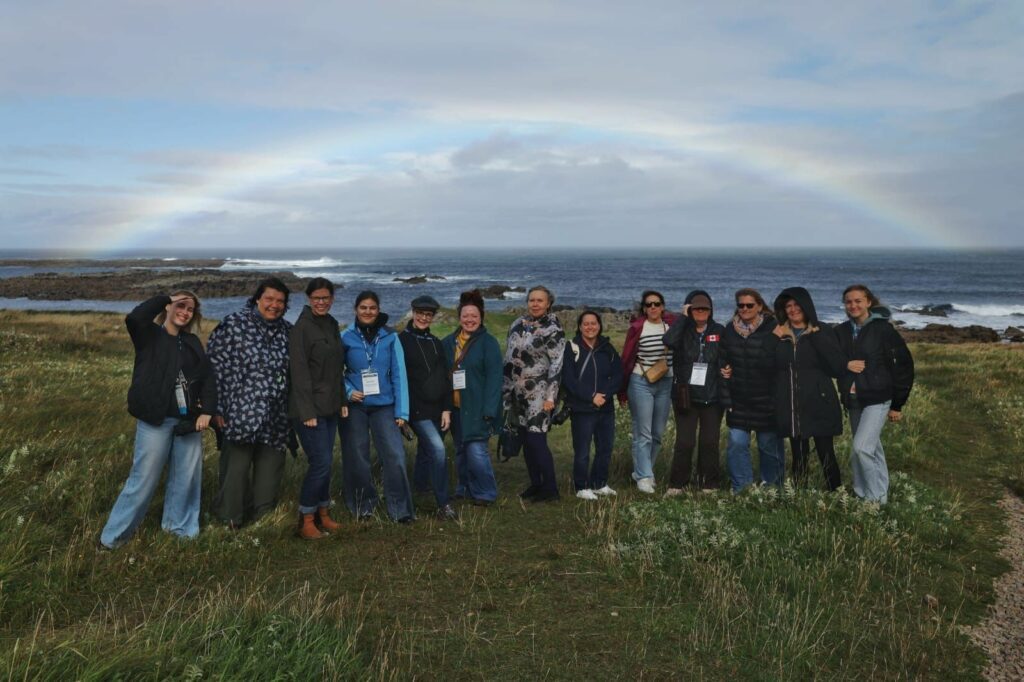 a group of people standing in front of a rainbow